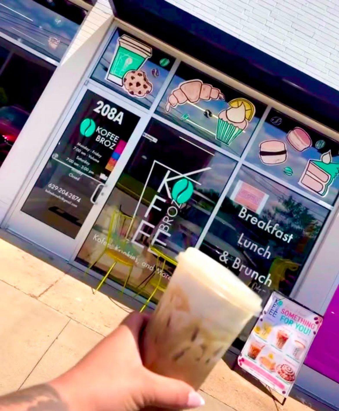 Raising an iced coffee outside the Kofee Broz storefront